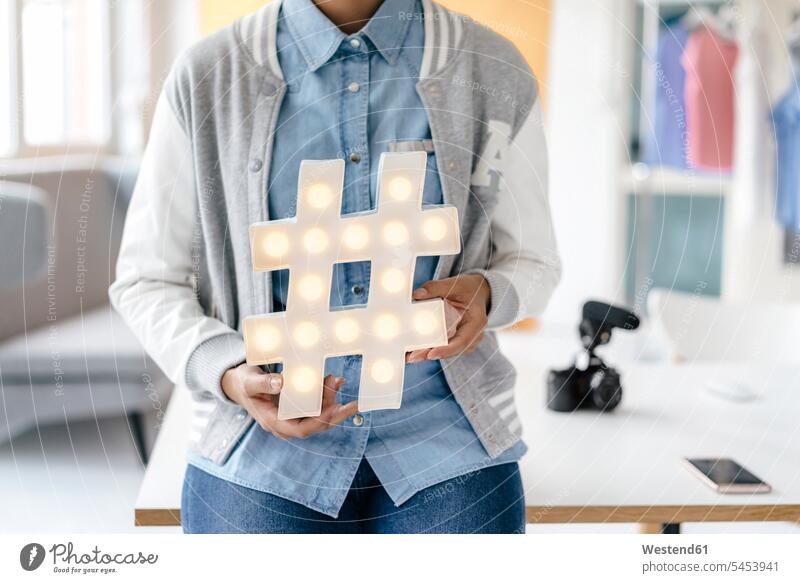 Young woman holding hashtag sign in studio females women studios Hashtag Adults grown-ups grownups adult people persons human being humans human beings