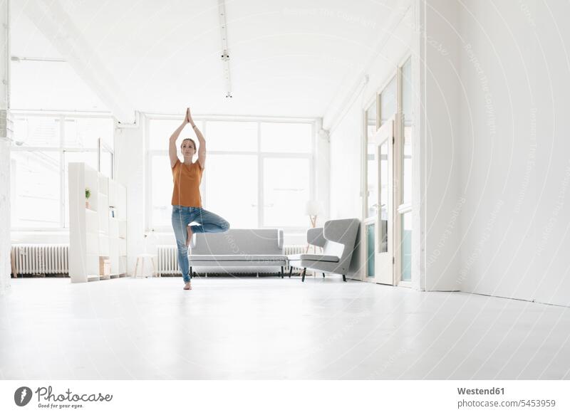 Woman practising yoga in a loft woman females women lofts Adults grown-ups grownups adult people persons human being humans human beings mindfulness aware