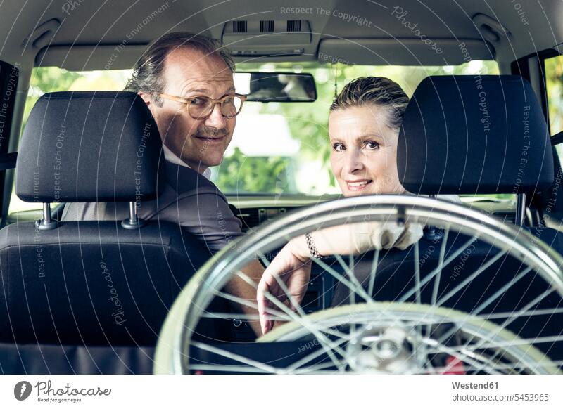 Smiling couple in car with wheelchair in boot automobile Auto cars motorcars Automobiles smiling smile twosomes partnership couples senior adults seniors old