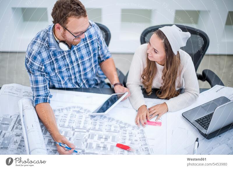 Young man and woman discussing project in design office Female Colleague designer designers design professional design professionals Design Occupation Office