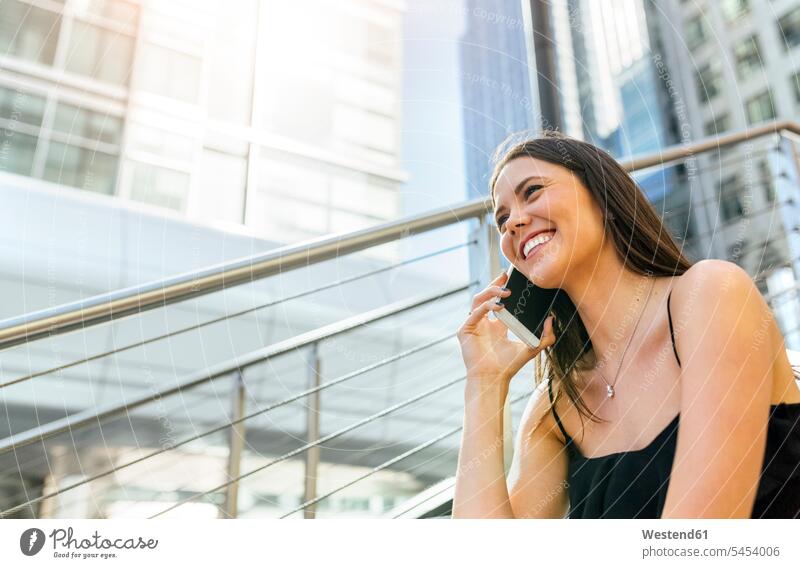 Smiling young woman on the phone in the city mobile phone mobiles mobile phones Cellphone cell phone cell phones females women call telephoning On The Telephone