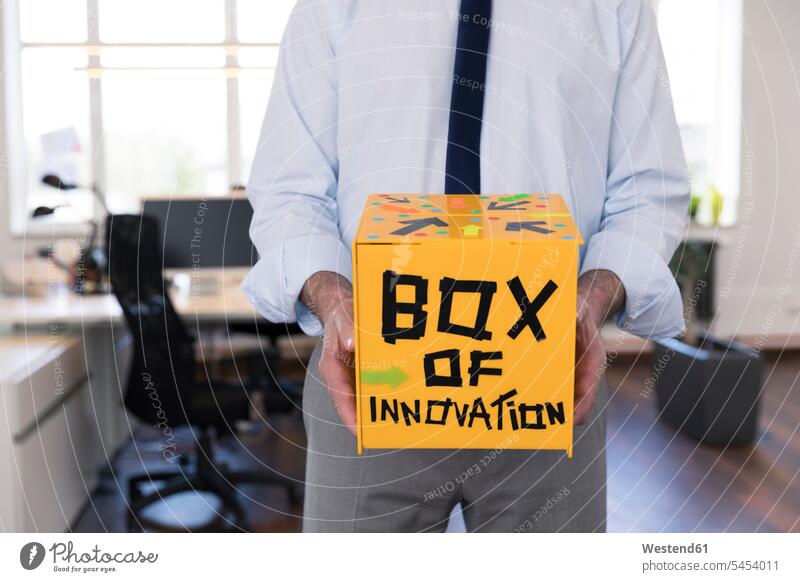 Businessman collecting innovative suggestions in yellow box Innovation holding boxes Business man Businessmen Business men Advice Suggestion submitting advise