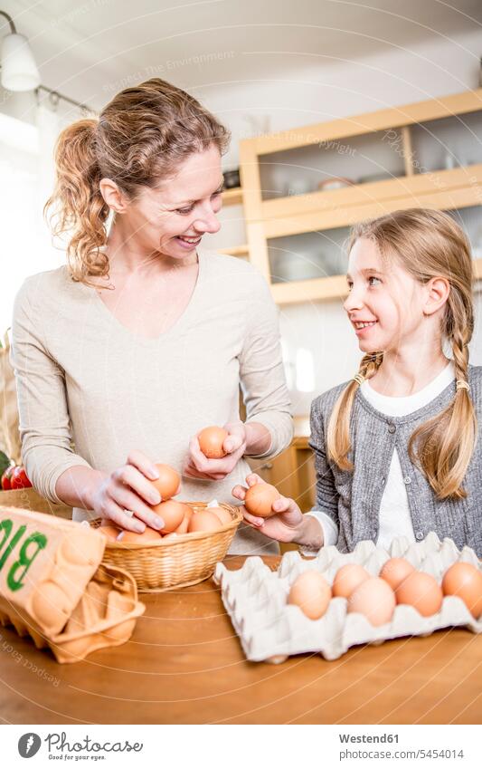Mother and daughter with eggs in kitchen Egg Eggs domestic kitchen kitchens daughters mother mommy mothers ma mummy mama Food foods food and drink Nutrition