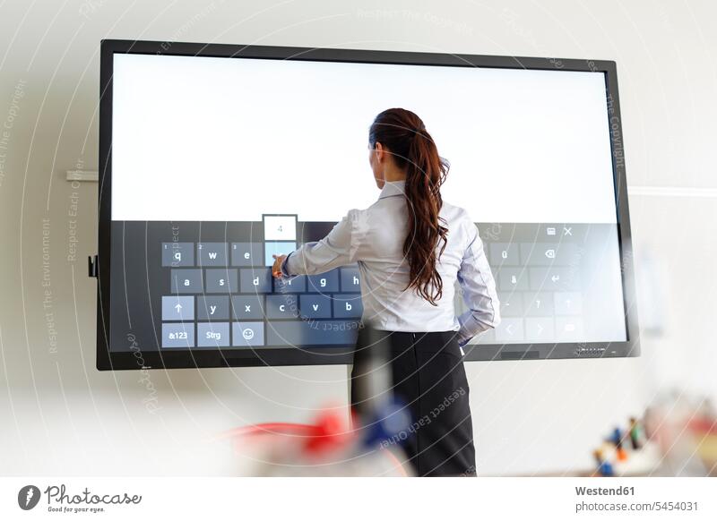 Businesswoman using projection of a keyboard in conferene room keyboards workshop Projection presentation presentations training training course screen screens