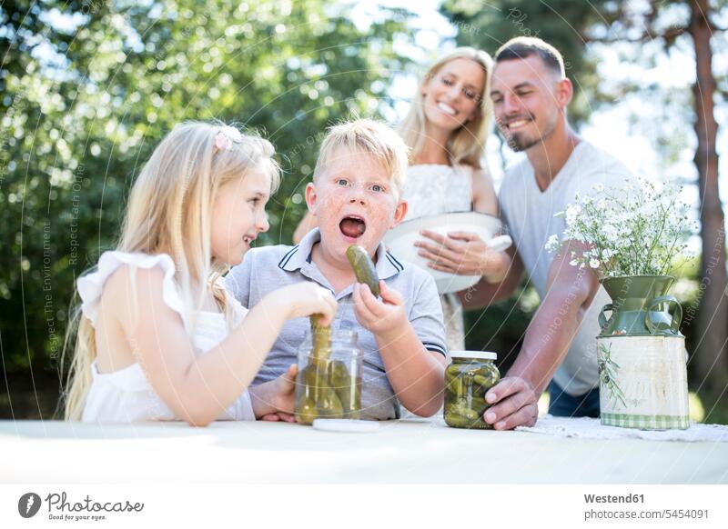 Portrait of boy with family eating gherkin outdoors boys males Gherkin Gherkins child children kid kids people persons human being humans human beings Cucumber