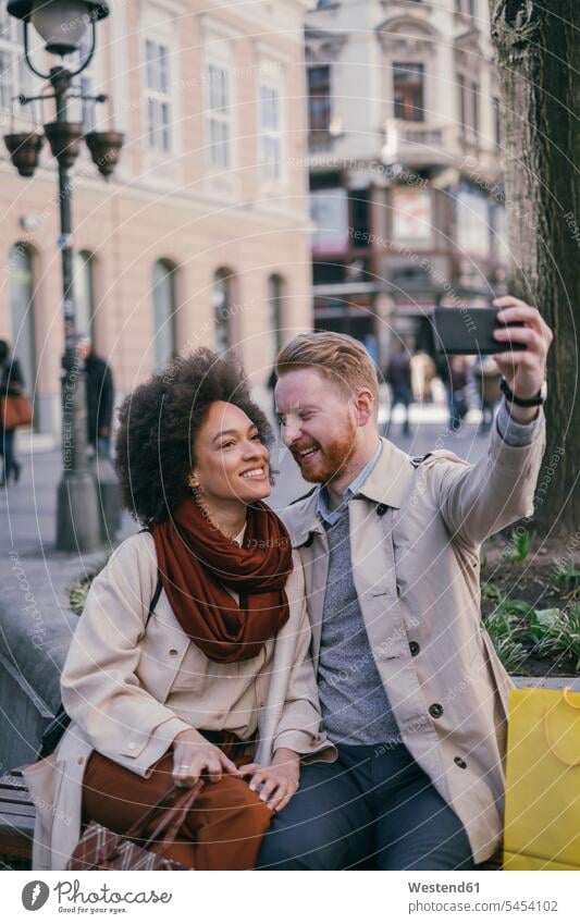 Happy couple taking a selfie in the city smiling smile Selfie Selfies twosomes partnership couples mobile phone mobiles mobile phones Cellphone cell phone