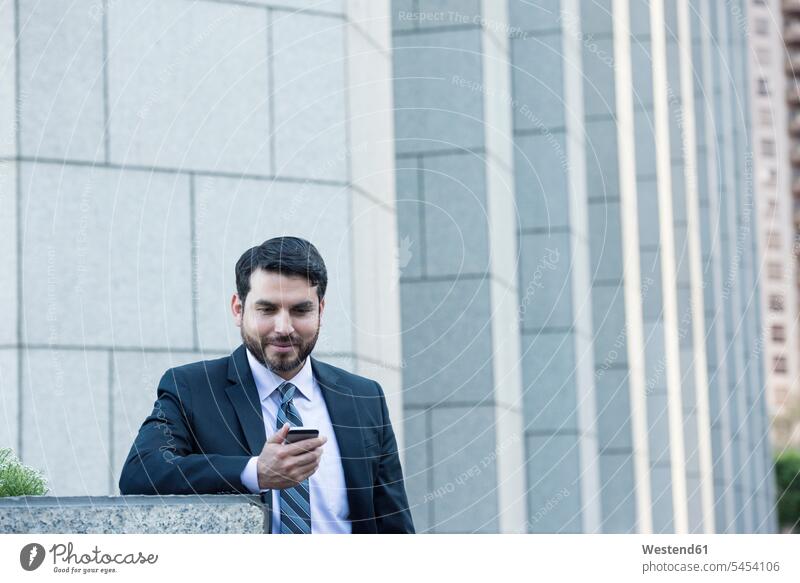 Businessman looking at cell phone mobile phone mobiles mobile phones Cellphone cell phones Business man Businessmen Business men portrait portraits telephones
