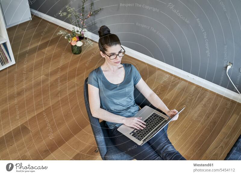 Young woman using laptop at home sitting Seated females women Laptop Computers laptops notebook Adults grown-ups grownups adult people persons human being