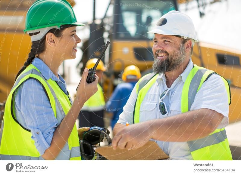 Male and female quarry workers discussing on site gravel pit blue collar worker blue-collar worker mining discussion working At Work work meeting briefing