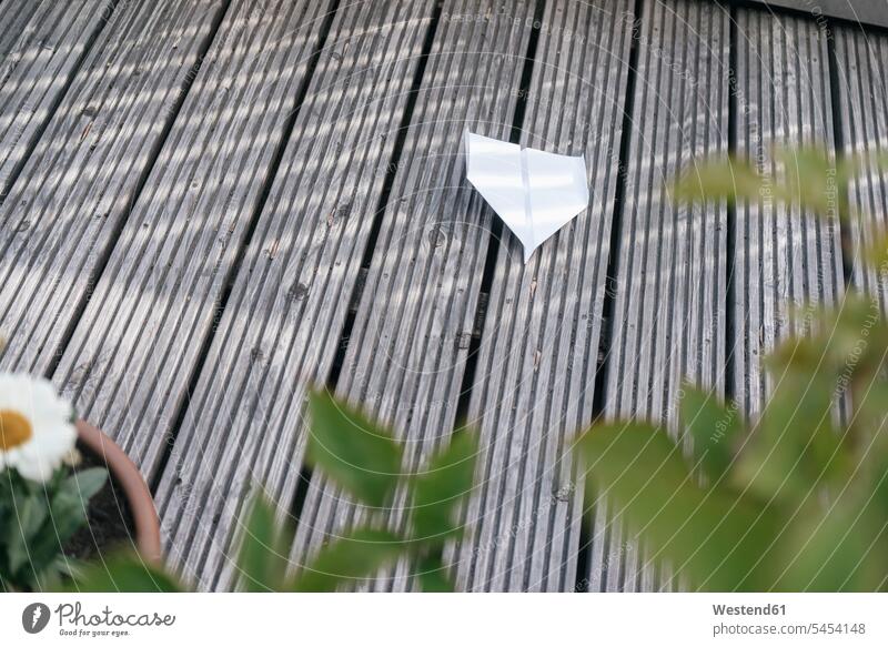 Paper plane on wooden terrace terraces paper plane paper dart paper planes paper darts paper aeroplane Paper Airplane toy toys outdoors outdoor shots