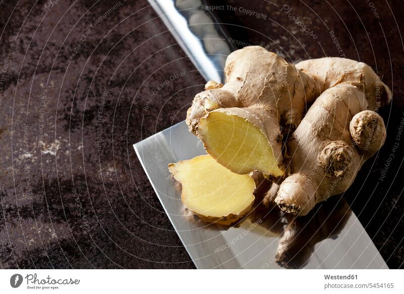 Fresh ginger on a cleaver nobody chopping knife chopper cleavers choppers chopping knives Corm Tubers Corms ginger root ginger roots studio shot studio shots