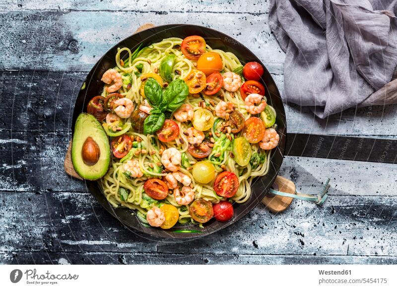Frying pan of spaghetti with zoodles, guacamole, tomatoes and shrimps yellow tomato yellow tomatoes vegetable noodles prepared ready to eat ready-to-eat