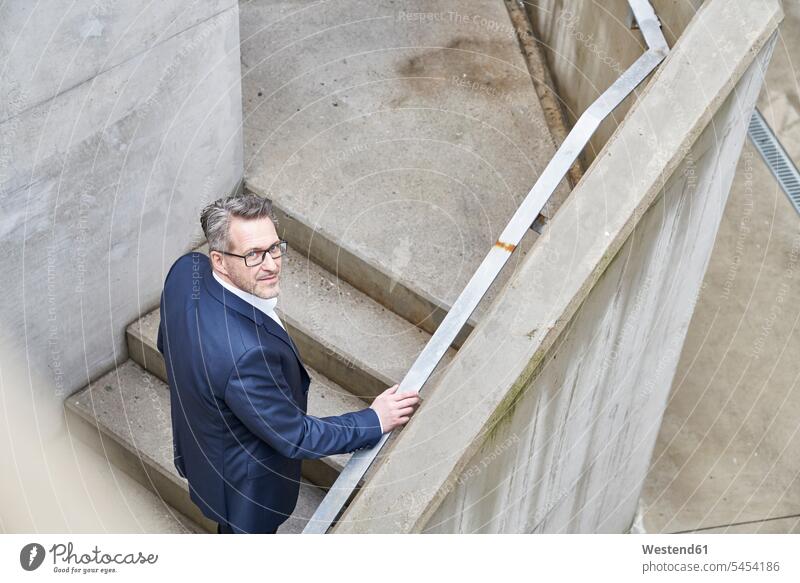 Portrait of businessman standing on stairs Businessman Business man Businessmen Business men stairway business people businesspeople business world