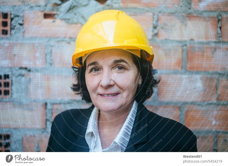 Portrait of confident woman wearing hard hat construction site Building Site sites Building Sites construction sites females women constructing Adults grown-ups