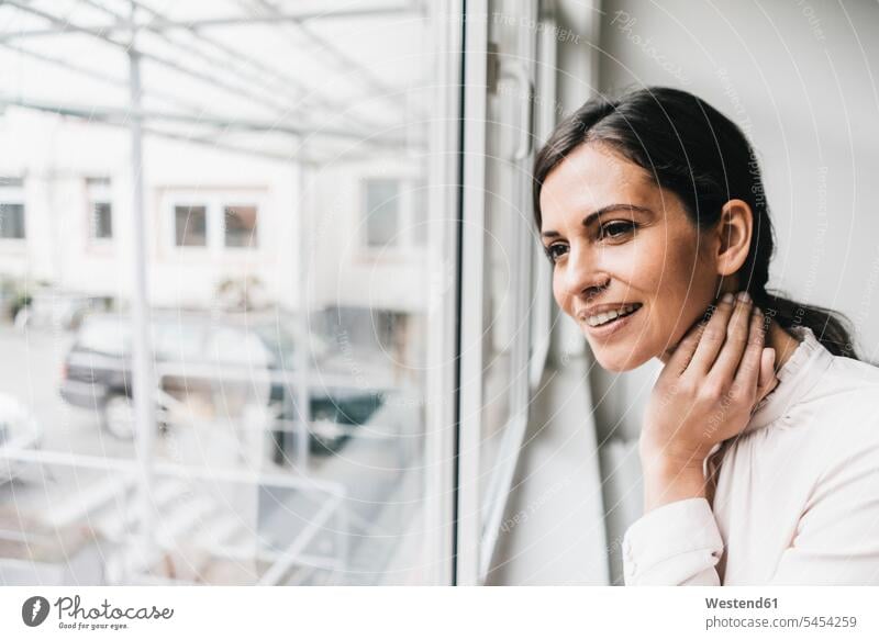 Smiling woman looking out of window portrait portraits windows females women smiling smile view seeing viewing Adults grown-ups grownups adult people persons