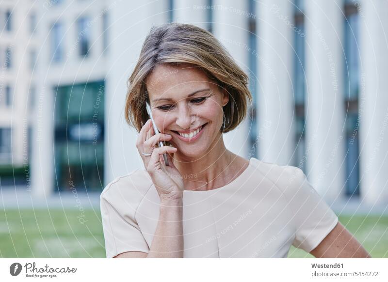 Smiling businesswoman on cell phone outdoors businesswomen business woman business women mobile phone mobiles mobile phones Cellphone cell phones smiling smile