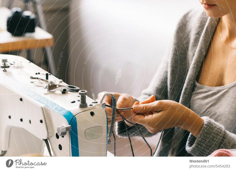 Close-up of woman using sewing machine working At Work seamstress seamstresses females women sewing machines tailor dressmakers tailors craftsman trade