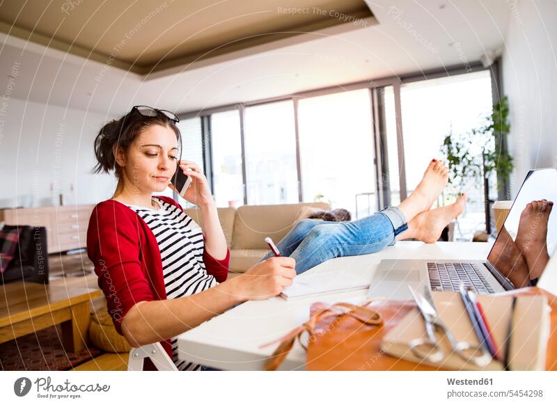 Woman on the phone working at desk at home desks call telephoning On The Telephone calling woman females women Table Tables telephone call Phone Call