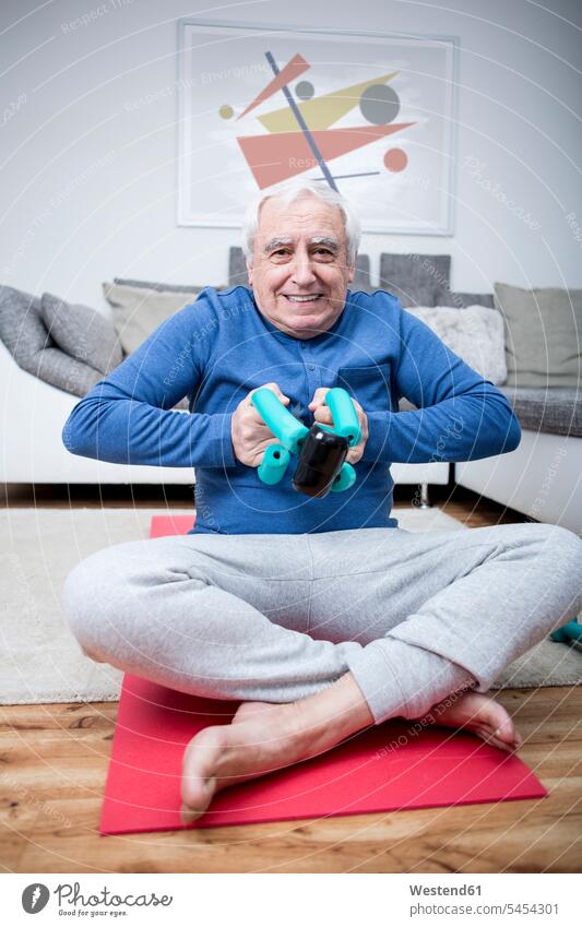 Senior man doing muscle training at home exercise exercises practising exercising dumbbell dumbbells dumb-bells sitting Seated practicing practice practise