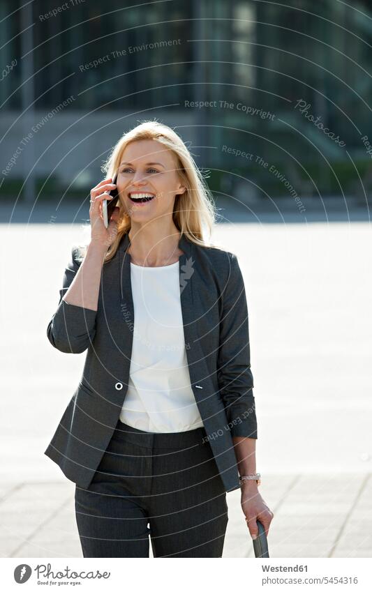 Portrait of laughing blond businesswoman on the phone businesswomen business woman business women portrait portraits call telephoning On The Telephone calling