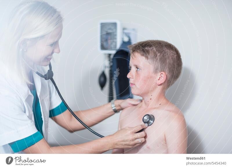 Female pedeatrician examining boy's lungs with stethoscope Auscultation auscultate auscultating boys males pediatrician paediatricians healthcare and medicine