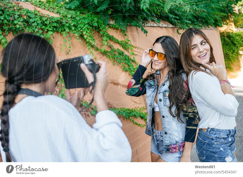 Young woman taking picture of her friends with camera taking a photo Taking Photos Taking A Picture take a photo Taking Picture Taking Pictures female friends
