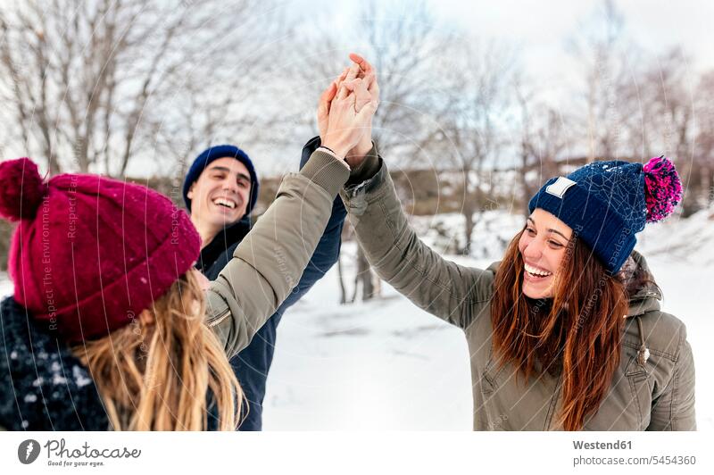 Three friends joining their hands in the snow winter hibernal Fun having fun funny friendship weather hand in hand happiness happy Hand Raised Raising Hands