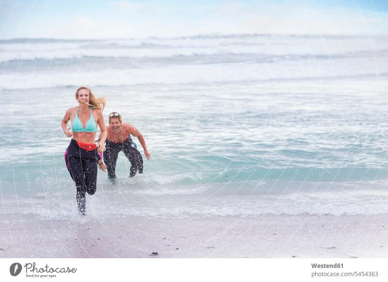 Couple having fun at the ocean couple twosomes partnership couples laughing Laughter Fun funny beach beaches people persons human being humans human beings