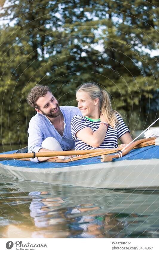 Happy young couple enjoying a canoe trip indulgence enjoyment savoring indulging excursion Getaway Trip Tours Trips happiness happy twosomes partnership couples