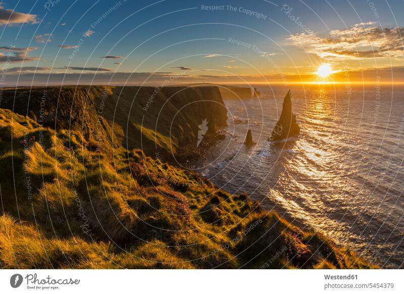 UK, Scotland, Caithness, Coast of Duncansby Head, Duncansby Stacks at sunrise rock rocks Highland Moody Sky Atlantic Coast Backlit back light backlight