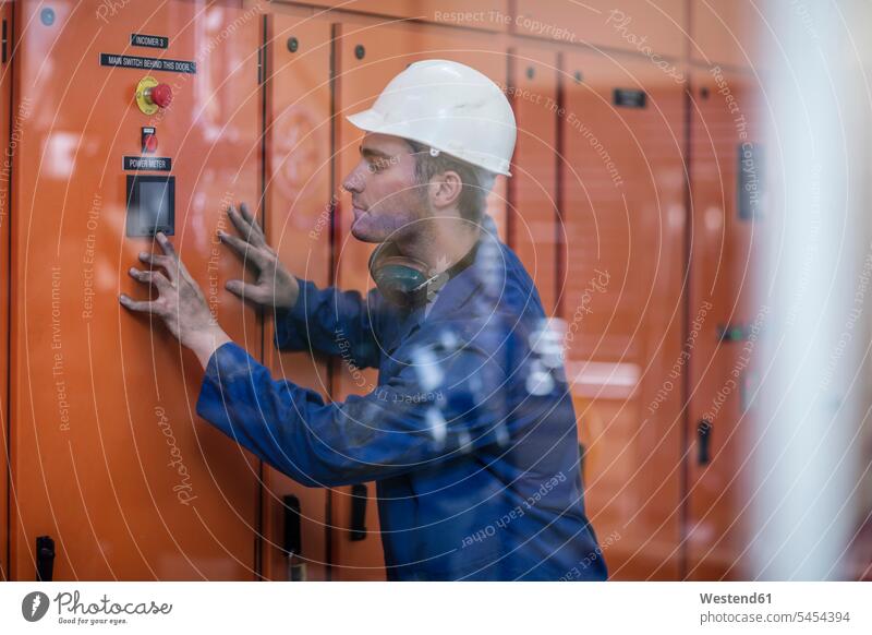 Worker operating machine in factory working At Work worker blue collar worker workers blue-collar worker Job Occupation man men males device devices Adults