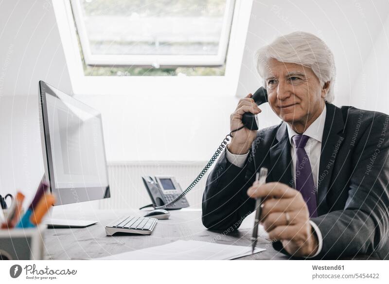 Senior businessman on the phone at his desk Businessman Business man Businessmen Business men portrait portraits office offices office room office rooms call