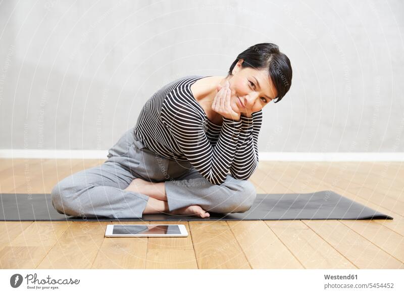 Smiling woman sitting on yoga mat with tablet exercise exercises Seated digitizer Tablet Computer Tablet PC Tablet Computers iPad Digital Tablet digital tablets