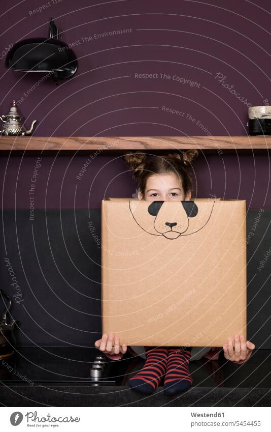 Girl inside a cardboard box painted with a panda girl females girls Cardboard Carton carton cardboard boxes Cardboards cartons playing child children kid kids