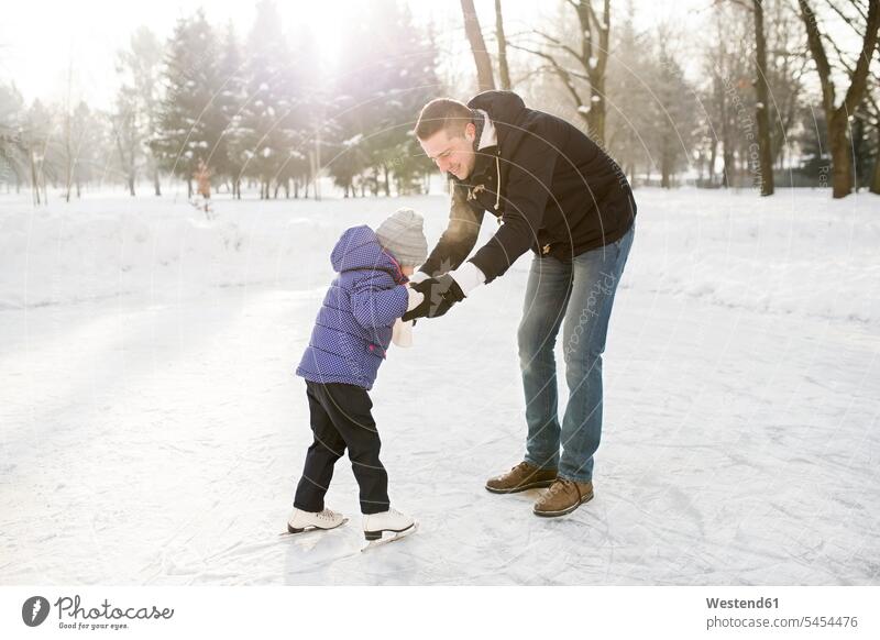 Father and daughter ice skating on frozen lake daughters father pa fathers daddy dads papa lakes Ice-Skating child children family families people persons