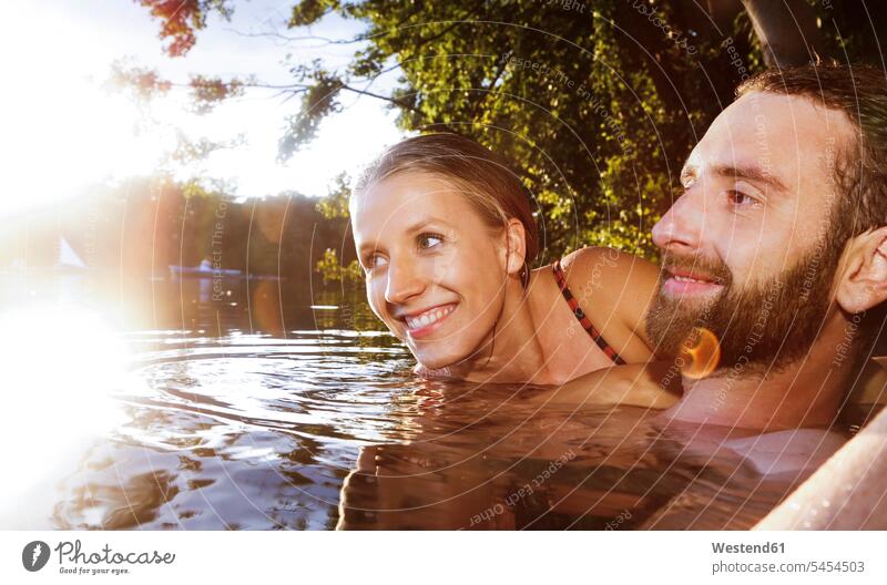 Happy young couple in a lake lakes twosomes partnership couples swimming happiness happy water waters body of water people persons human being humans
