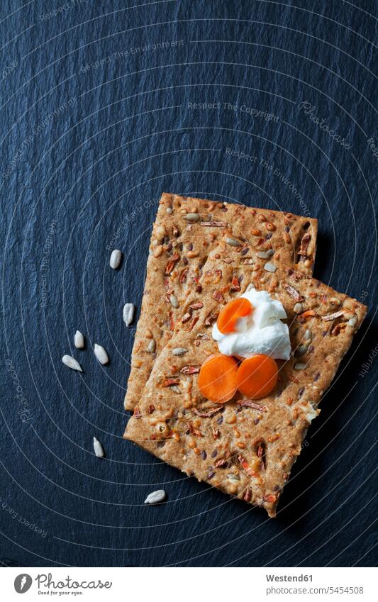 Two slices of carrot sunflower seed crispbread with curd and fresh carrot slices on slate food and drink Nutrition Alimentation Food and Drinks baked goods