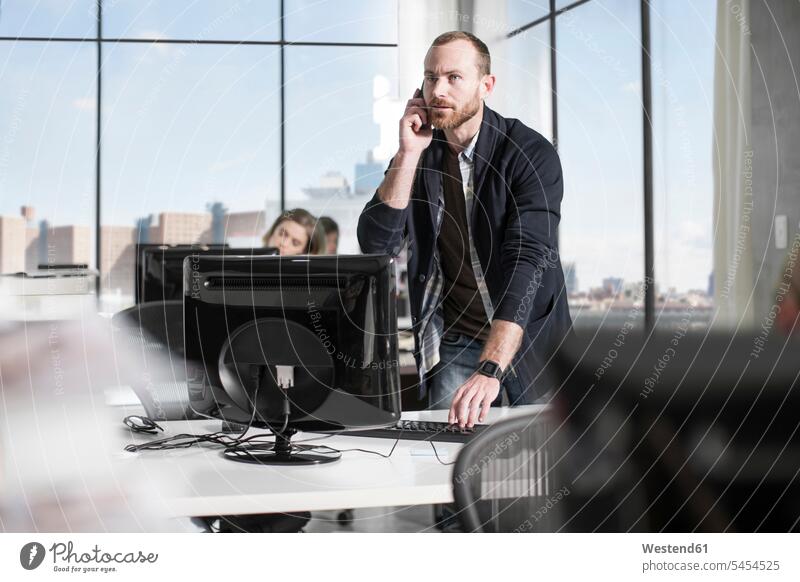 Man on the phone in office offices office room office rooms call telephoning On The Telephone calling man men males working At Work workplace work place