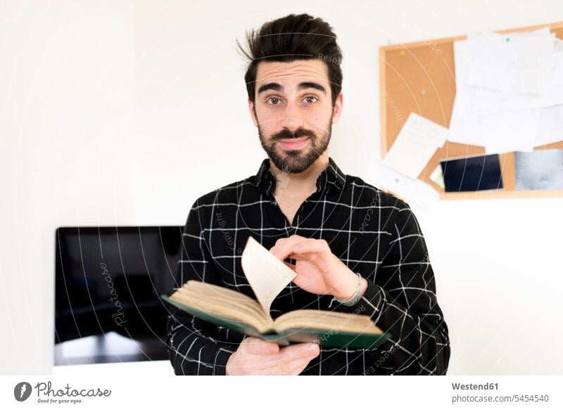 Portrait of man holding book books men males Adults grown-ups grownups adult people persons human being humans human beings beard student students front view