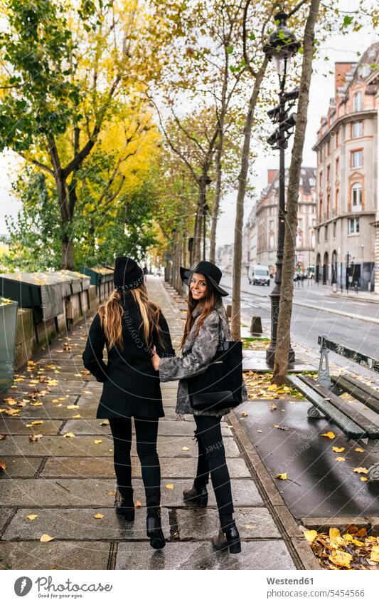 Paris, France, two women strolling near the Seine River female friends mate friendship pavement Side Walk female tourist turning turning around turning round