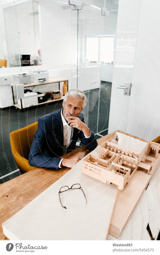 Mature businessman with architectural model in office models architects Businessman Business man Businessmen Business men offices office room office rooms