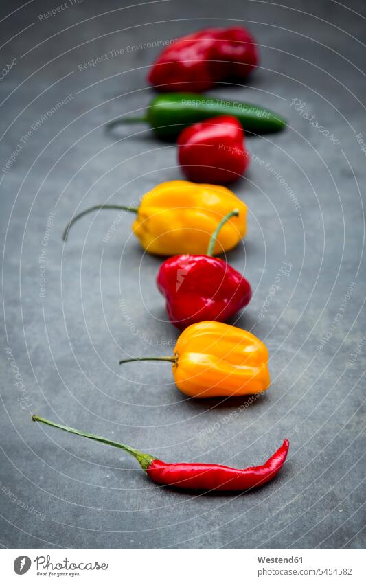 Row of various chili pods on grey ground food and drink Nutrition Alimentation Food and Drinks red chili pepper hot pepper peppers Red Peppers hot peppers
