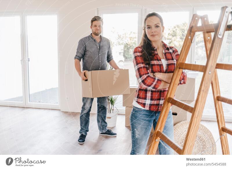 Couple moving house, carrying boxes in new home couple twosomes partnership couples move Moving Home property owner owners flat flats apartment apartments