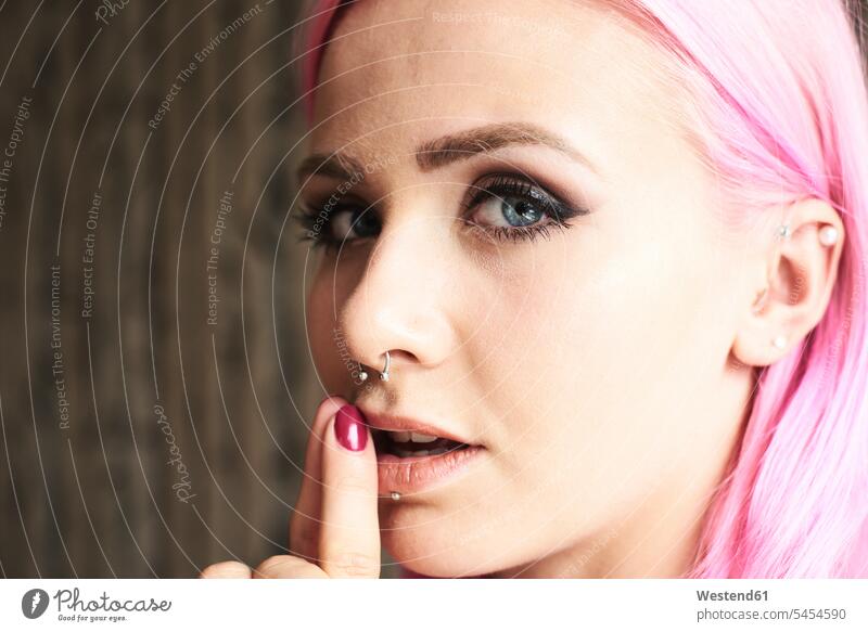 Portrait of young woman with pink hair and piercings serious earnest Seriousness austere females women portrait portraits Adults grown-ups grownups adult people