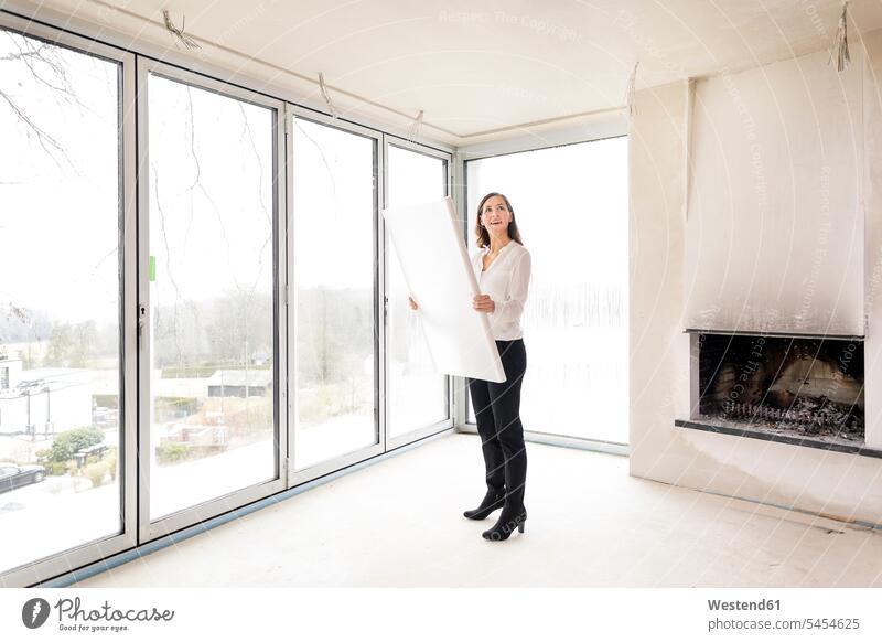 Woman in empty apartment with plan plans female real estate agent woman females women flat flats apartments architect female architect architects