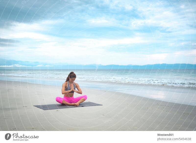 Woman practicing yoga on the beach beaches fit practice practise exercise exercising practising sportive sporting sporty athletic woman females women