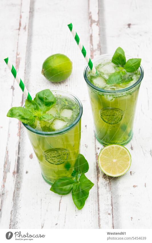 Two glasses of organic lime lemonade with basil Glass Glasses wooden half halves halved prepared aroma flavour aromatic garnished ready to eat ready-to-eat