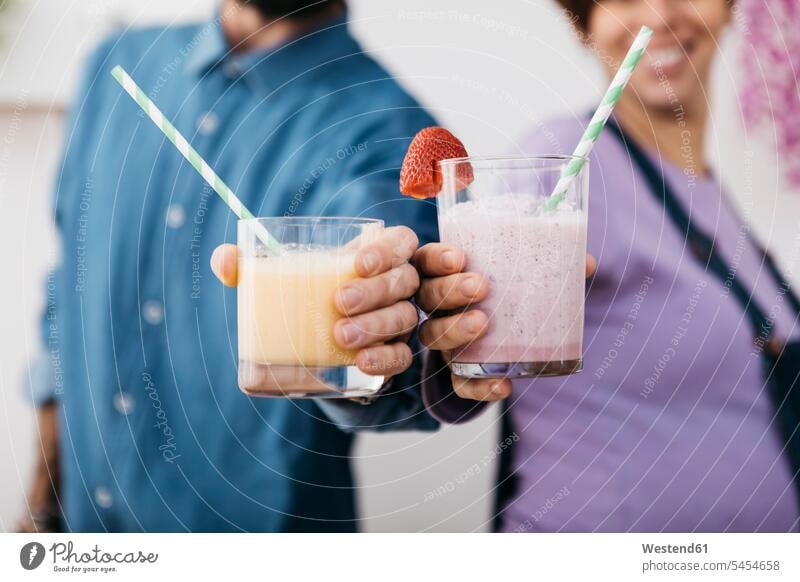 Couple with glasses of different smoothies ready to drink, partial view couple twosomes partnership couples Smoothies people persons human being humans