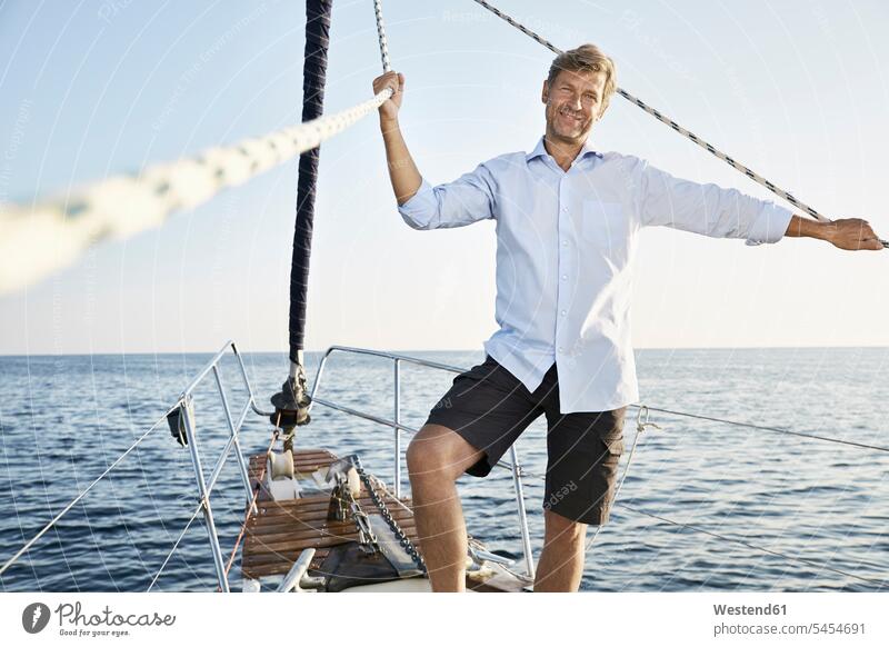 Portrait of smiling mature man on his sailing boat men males portrait portraits Adults grown-ups grownups adult people persons human being humans human beings