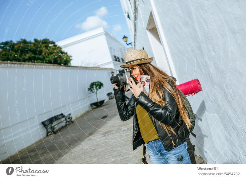 Young traveling woman taking photos in a town camera cameras photographing females women Adults grown-ups grownups adult people persons human being humans